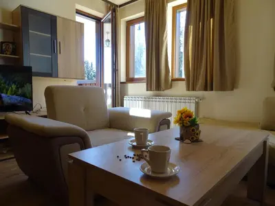 a living room with a wooden table with cups on it at APARTMENT Darsi in Pamporovo