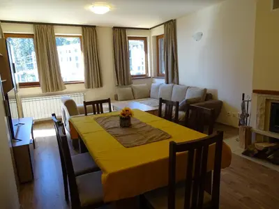a living room with a table with a yellow table cloth at APARTMENT Darsi in Pamporovo