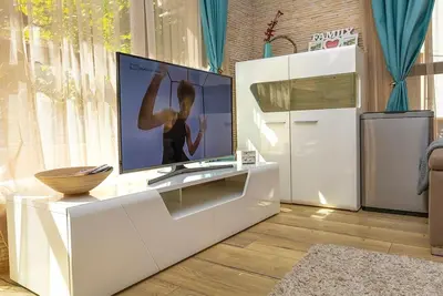 a living room with a television on a white entertainment center at 2BR apartment ,10 minutes walk to TOP Center in Plovdiv