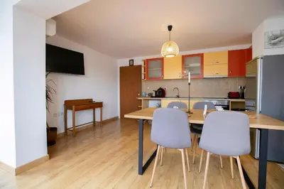 a kitchen and dining room with a table and chairs at Cozy Apartment with Mountain View & Parking in Sofia