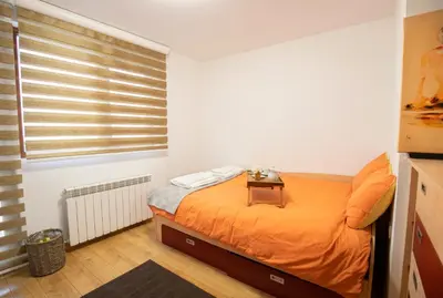 a bedroom with an orange bed and a window at Cozy Apartment with Mountain View & Parking in Sofia