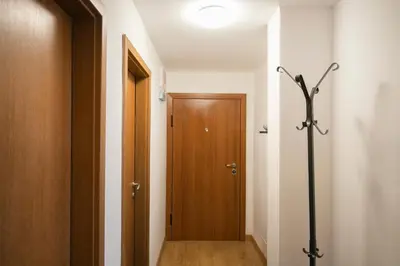 a hallway with a wooden door and a wooden floor at Cozy Apartment with Mountain View & Parking in Sofia