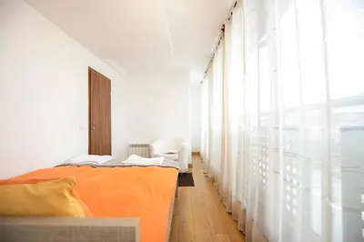 a bedroom with an orange bed and a window at Cozy Apartment with Mountain View & Parking in Sofia
