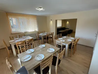 a dining room with wooden tables and chairs at Villa Stoyanovata Kashta in Samokov