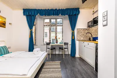 a bedroom with a bed and a table with chairs at House Of History , Rooms in the Main Street Plovdiv in Plovdiv