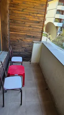 two chairs and a table on a balcony at Апартамент Николови Пампорово in Pamporovo
