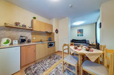 a kitchen and a living room with a table in a room at Cozy and Cute 1BD Apartment in The Castle Complex by Flat Mаnager in Pamporovo