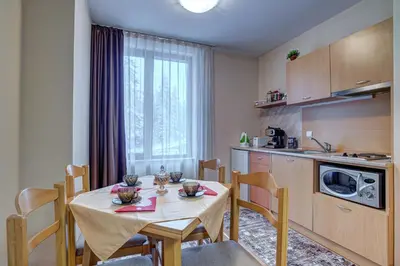 a kitchen with a table and chairs and a kitchen with a table and a kitchen at Cozy and Cute 1BD Apartment in The Castle Complex by Flat Mаnager in Pamporovo