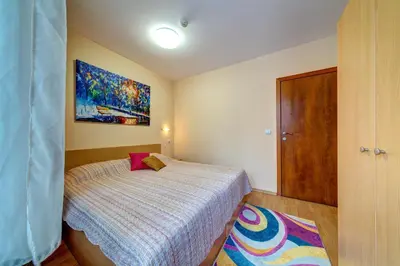a bedroom with a bed and a painting on the wall at Cozy and Cute 1BD Apartment in The Castle Complex by Flat Mаnager in Pamporovo
