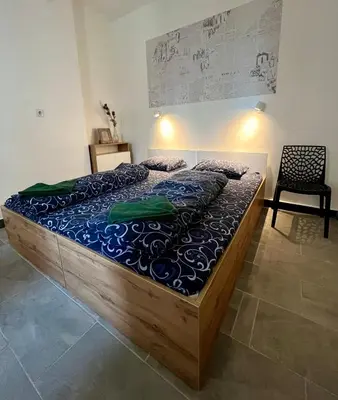 a large bed in a room with a chair at The rainbow 2 in Sofia