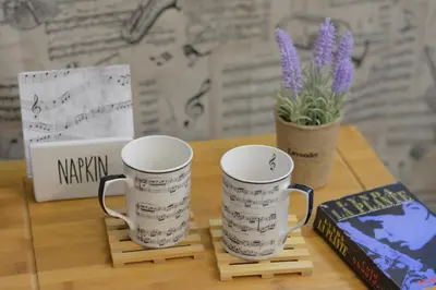 a table with two coffee mugs and a book at The Music House - Exclusive Studio in the Heart of Sofia by Flat Mаnager in Sofia