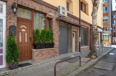 a brick building with a brown door on a street at The Music House - Exclusive Studio in the Heart of Sofia by Flat Mаnager in Sofia