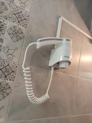 a shower coil is attached to a wall in a bathroom at Студио Еми in Chepelare