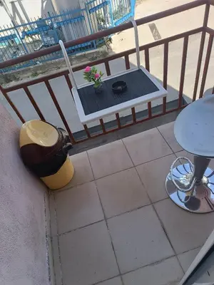 a balcony with a bench and a table and a plant at Студио Еми in Chepelare