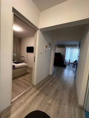 a room with a bedroom and a bed and a mirror at Eli's cozy place in Sofia