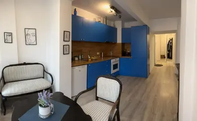 a kitchen with blue cabinets and a table and chairs at Eli's cozy place in Sofia