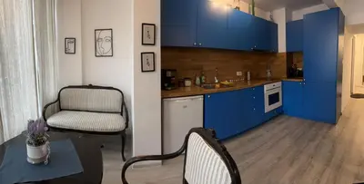 a kitchen with blue cabinets and a table and a chair at Eli's cozy place in Sofia