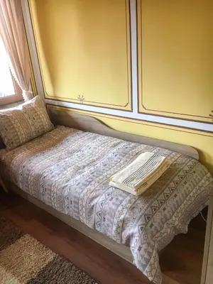 a small bed in a room with a window at Стаи за гости Бащино огнище in Koprivshtitsa