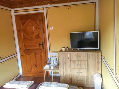 a living room with a television on a wooden cabinet at Стаи за гости Бащино огнище in Koprivshtitsa