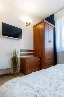 a bedroom with a large bed and a wooden cabinet at Snow Line Suites SLS in Bansko