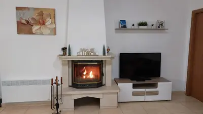 a living room with a fireplace and a tv at Apartments WinterFell ,Grand Monastery ,Pamporovo in Pamporovo