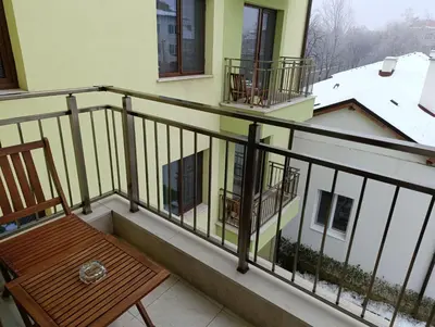 a balcony with a wooden chair and a snow covered roof at Lime House, Kyustendil in Kyustendil