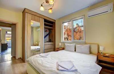 a bedroom with a large white bed with a window at 1BD Nest in the heart of a traditional Sofia by Flat Mаnager in Sofia