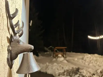 a reindeer head with a bell in a window at The Forest Villa Borovets by BookVillaBG in Borovets
