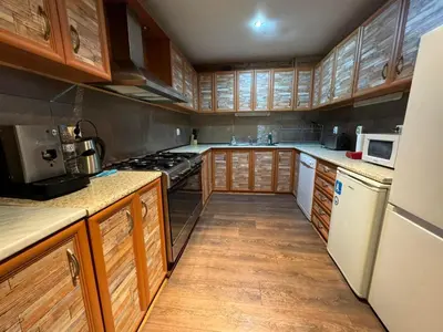 a kitchen with wooden cabinets and a white refrigerator at Chalet Iskar Borovets by BookVillaBG in Borovets