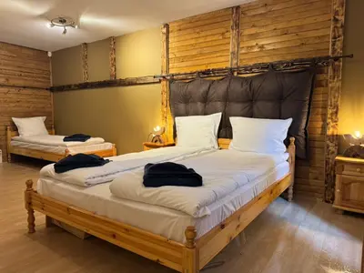two beds in a room with wooden walls at Chalet Iskar Borovets by BookVillaBG in Borovets