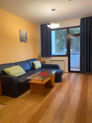 a living room with a blue couch and a coffee table at HQ Apartment Flora Violet in Borovets