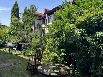 a garden with chairs and a table and a house at Cozy mountain apartament near the Gondola lift in Bansko