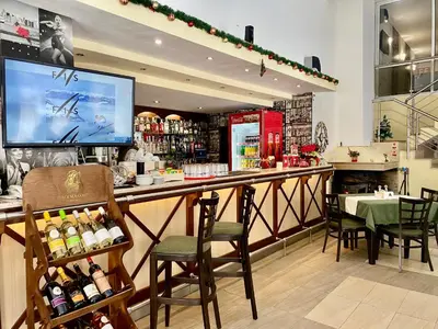 a restaurant with a bar with chairs and a tv at Antonovi Apartments 1 in hotel Laplandia in Pamporovo