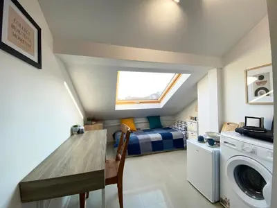 a bedroom with a bed and a table and a washing machine at LK17 - Loft in the Center in Sofia