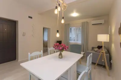 a living room with a white table with flowers on it at Graf Ignatiev Central Apartment in Sofia