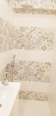 a bathroom with a white sink and a tile wall at Graf Ignatiev Central Apartment in Sofia