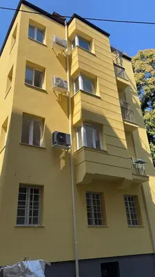 a yellow building with windows and a street light at Graf Ignatiev Central Apartment in Sofia