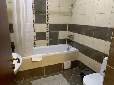 a bathroom with a bath tub and a toilet at Flora Clover One Bedroom Apartment nr. 18 in Borovets