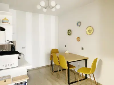 a dining room with a table and yellow chairs at Altavista mountain apartment in Samokov