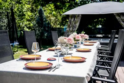 a long table with plates and wine glasses on it at Къща за гости ЗЕЛЕНА in Vinogradets
