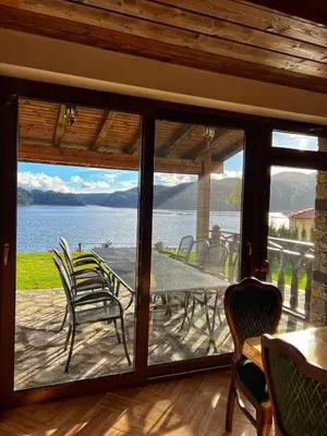 a screened in porch with a table and chairs at OASIS RESORT RHODOPES in Dospat
