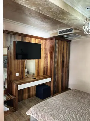 a bedroom with a bed and a flat screen tv at OASIS RESORT RHODOPES in Dospat
