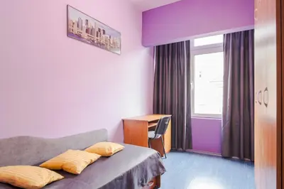 a bedroom with a bed and a desk and a window at Your home away from home in Sofia