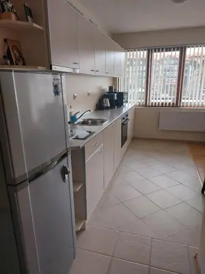 a kitchen with white cabinets and a refrigerator at Apartment Pirin in Bansko