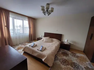 a bedroom with a bed and a large window at Apartment Pirin in Bansko