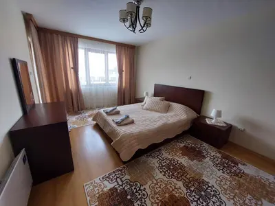 a bedroom with a bed and a large window at Apartment Pirin in Bansko