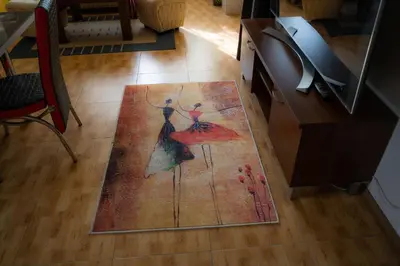a floor rug with a picture of two dancing women at Апартамент ДЕНИ in Pamporovo