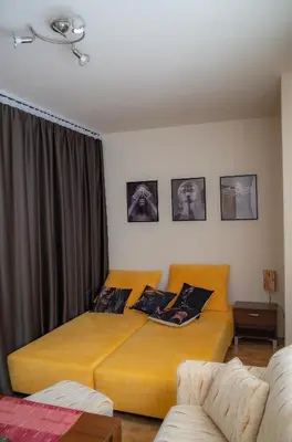 a bedroom with two beds with pictures on the wall at Апартамент ДЕНИ in Pamporovo