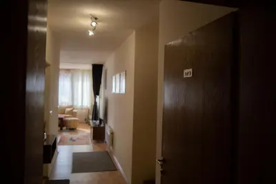 a hallway with a door and a living room at Апартамент ДЕНИ in Pamporovo
