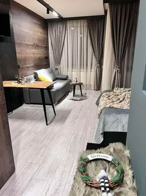 a living room with a couch and a table at Апартамент - Боровец Хотел ''Боровец Гардънс'' A 44 in Borovets